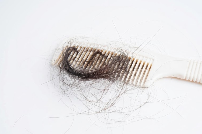 Loose hair strands caught in a hairbrush after brushing