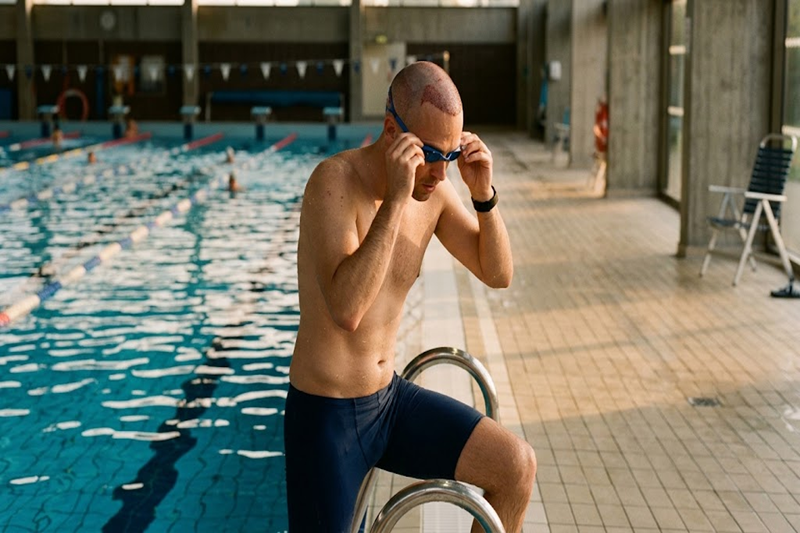Man preparing to swim after hair transplant recovery